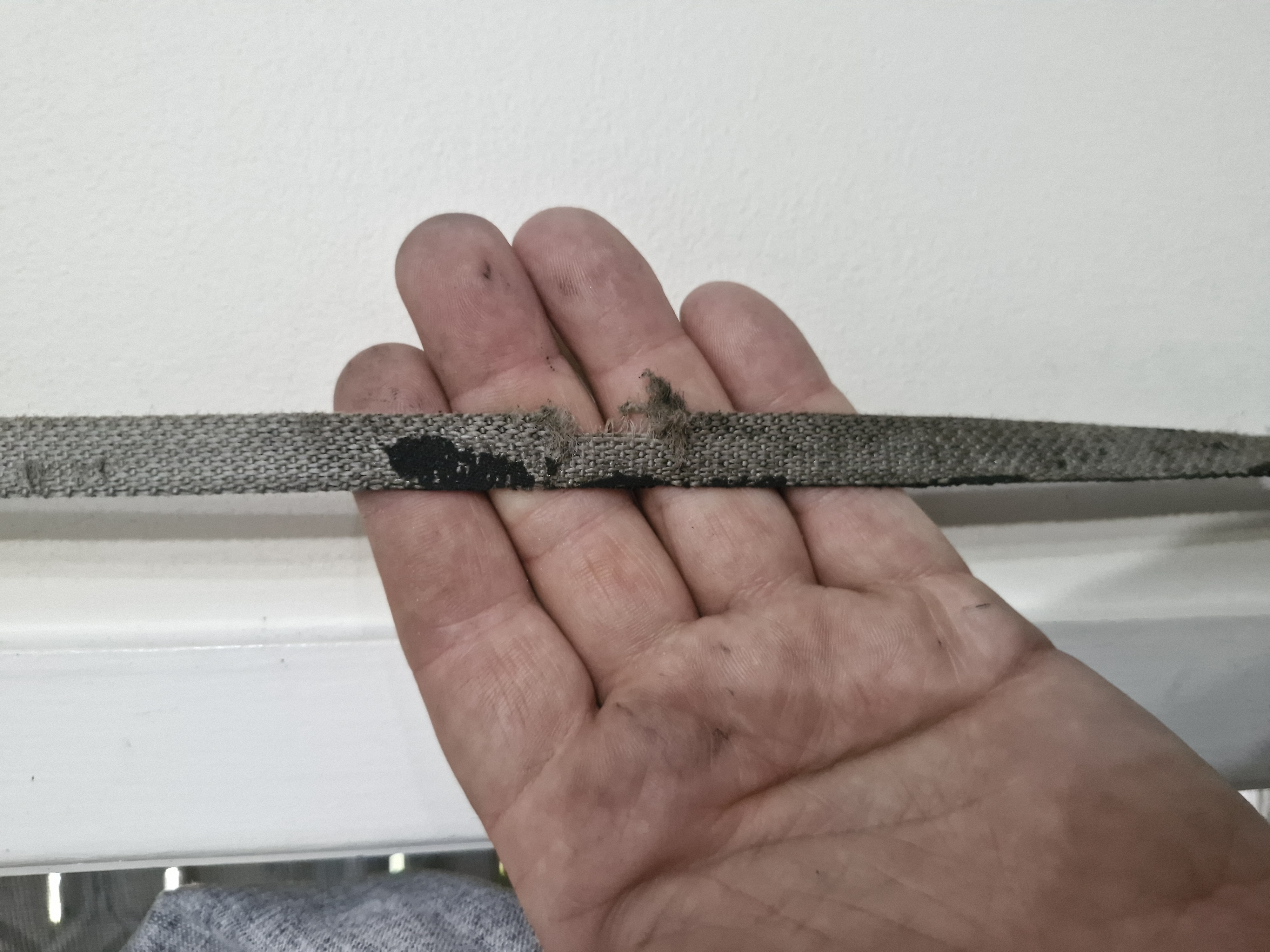 Worn roller shutter strap held for inspection — strap replacement Sydney